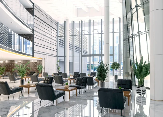Interior view of a modern lobby featuring seating arrangements and indoor plants.