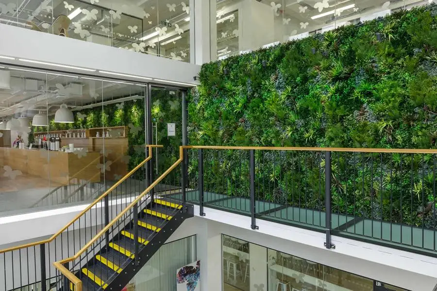 A custom faux green wall featuring various types of greenery in an indoor setting.