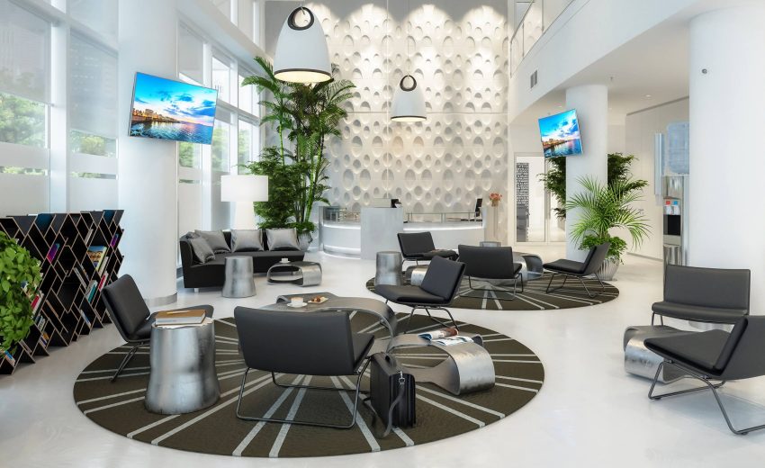 Contemporary office lobby featuring black chairs, round tables, and decorative plants, creating a welcoming atmosphere for visitors.