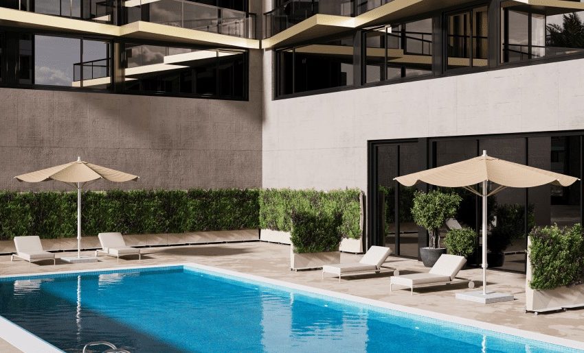 Modern swimming pool featuring lounge chairs and umbrellas in a contemporary outdoor setting with greenery.