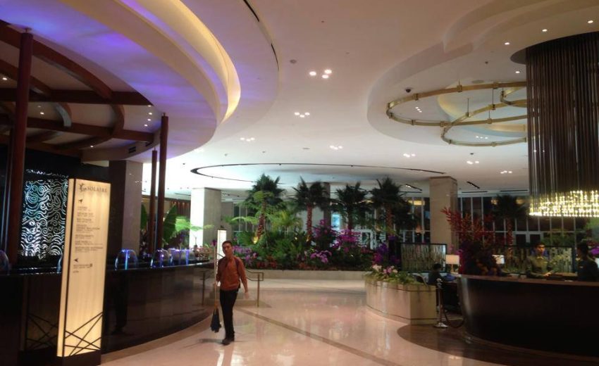Elegant hotel lobby featuring modern design, lush plants, and stylish lighting fixtures, creating a welcoming atmosphere for guests.