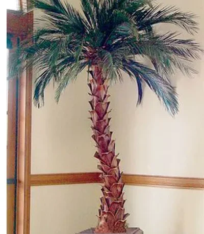 Artificial palm tree with a textured trunk and green fronds in a decorative pot.