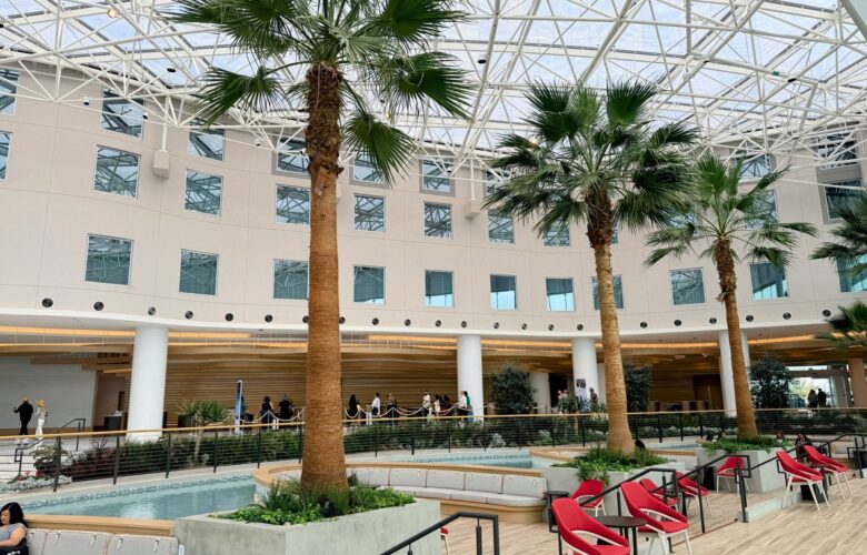 Indoor area featuring palm trees and modern seating arrangements in a well-lit environment.