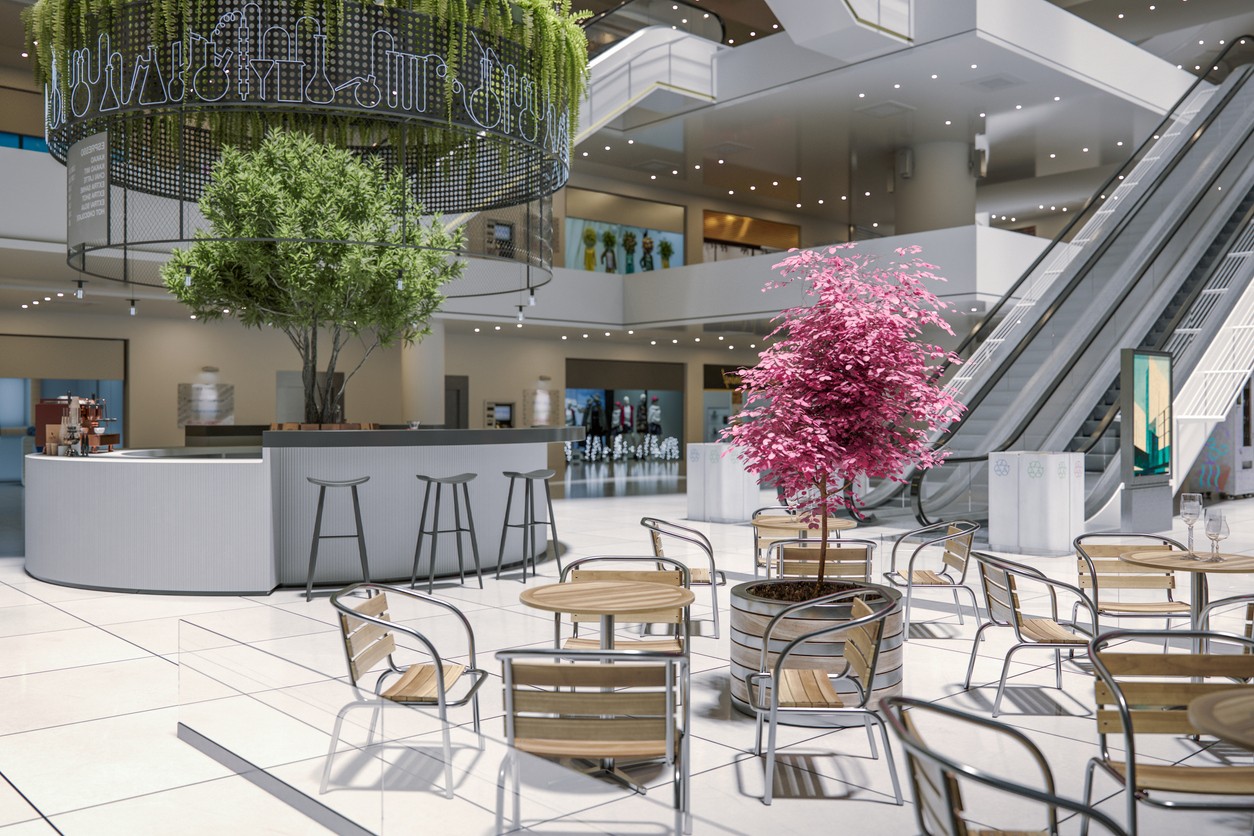 Indoor seating area featuring a pink tree and green foliage in a modern space with tables and chairs.