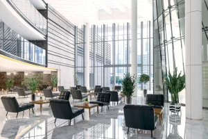 Interior view of a modern lobby featuring seating arrangements and indoor plants.